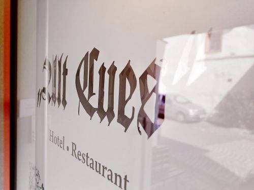 Spiegelung des Schriftzugs zum Hotel und Restaurant in einer Glasscheibe